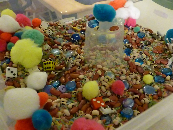 Sensory bin with cotton balls, rice, beans and dice