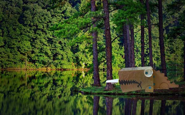 MAKEDO dinosaur out of recycled boxes, Photoshopped beside a lake