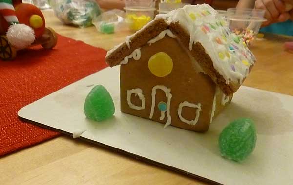 Yellow awning cottage gingerbread house from a kit