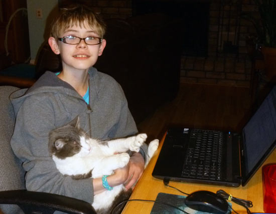 Ashar and cat Mitts helping with family business computer work